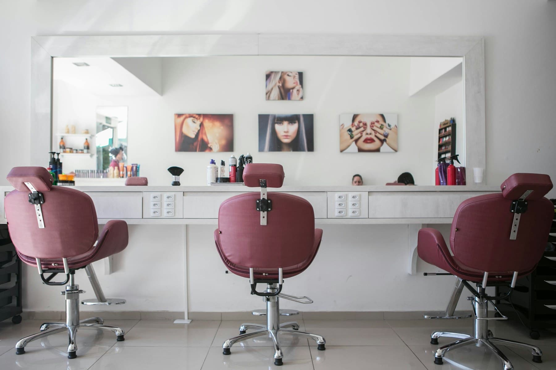 Hair stylist preparing tools beside a salon chair